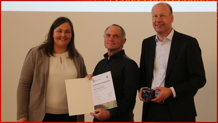 Bezirks-Vorsitzende Sabrina Hüttmann, Anton Fent und Bezirkstagspräsident Martin Sailer bei der Übergabe von Uhr und Urkunde im Rahmen des Bezirks-Ehrenamtstags Schwaben im Kloster Irsee.